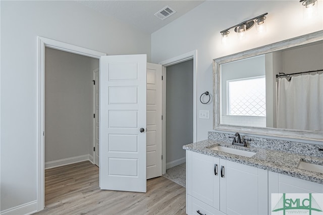 bathroom with a shower with curtain, vanity, wood-type flooring, and a textured ceiling