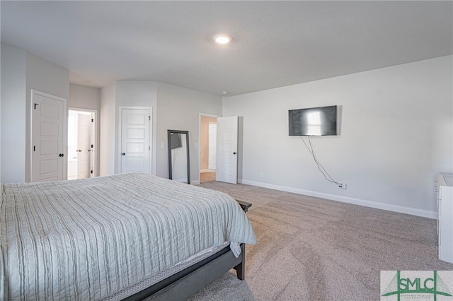 bedroom with connected bathroom and carpet