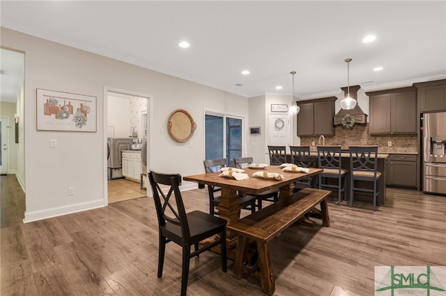 dining area with washer / dryer and hardwood / wood-style flooring