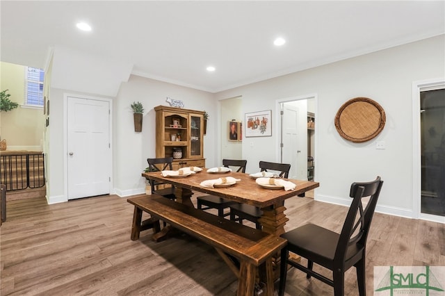 dining area with crown molding and light hardwood / wood-style floors