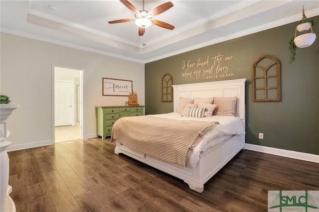 bedroom with ceiling fan, dark hardwood / wood-style flooring, crown molding, and a tray ceiling