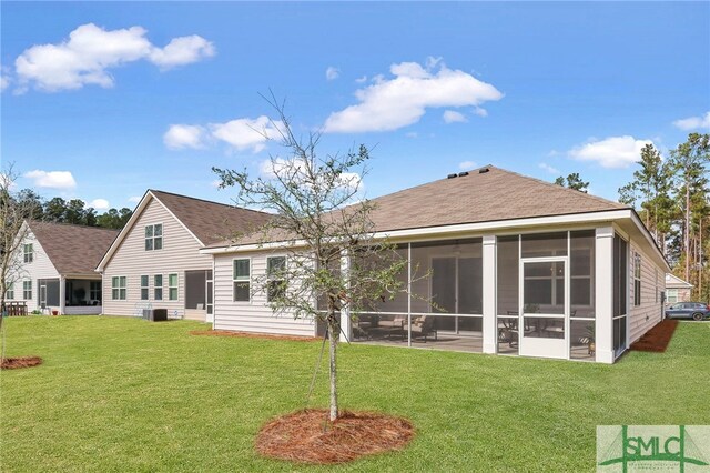 back of house featuring a lawn, a sunroom, and central AC unit