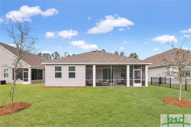 back of property featuring a sunroom and a yard