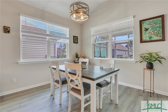 dining area with a notable chandelier and light hardwood / wood-style floors