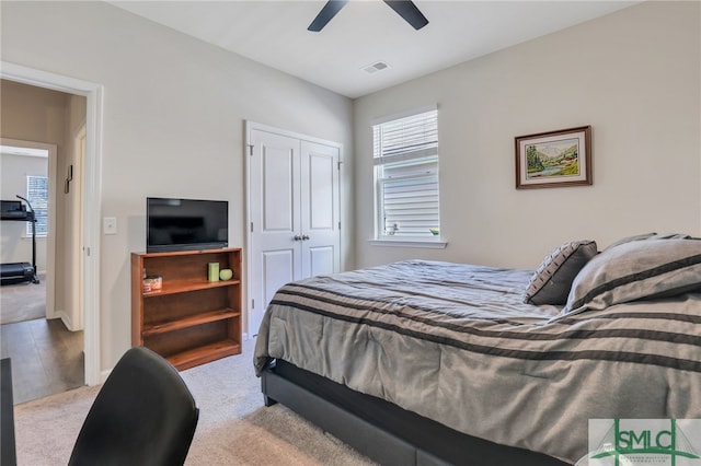 carpeted bedroom featuring ceiling fan and a closet