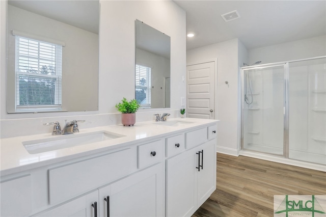 bathroom with vanity, hardwood / wood-style flooring, and a shower with door