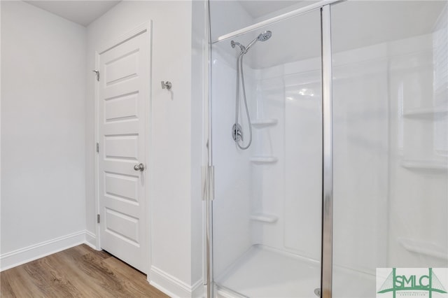 bathroom featuring hardwood / wood-style floors and a shower with door