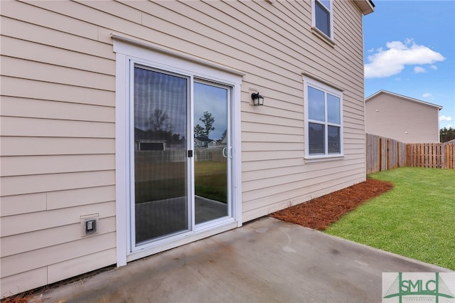 entrance to property with a patio area and a yard