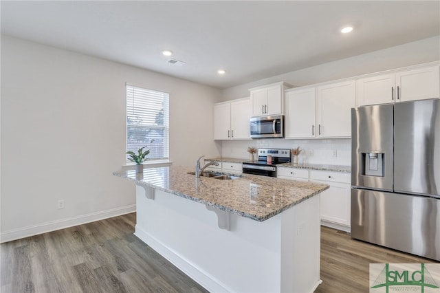 kitchen with sink, stainless steel appliances, wood-type flooring, a center island with sink, and white cabinets