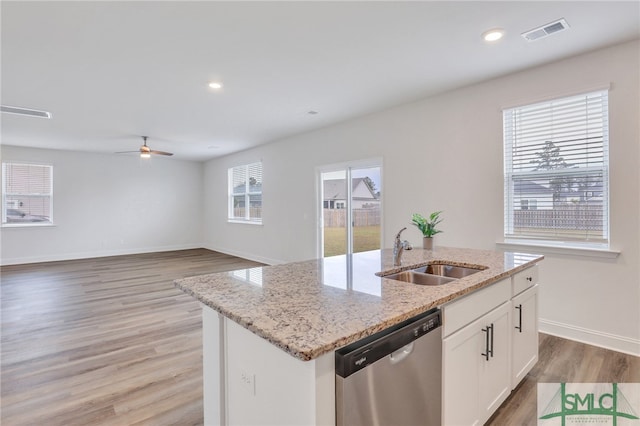 kitchen featuring white cabinets, sink, stainless steel dishwasher, hardwood / wood-style flooring, and an island with sink