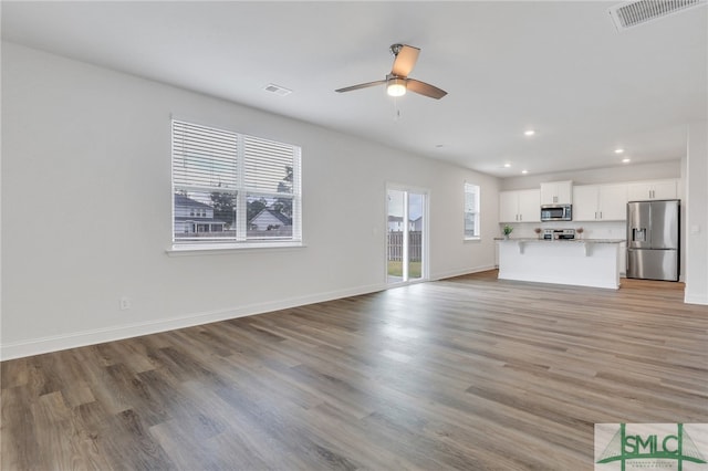 unfurnished living room featuring ceiling fan and light hardwood / wood-style flooring