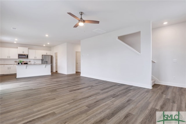 unfurnished living room featuring light wood-type flooring and ceiling fan