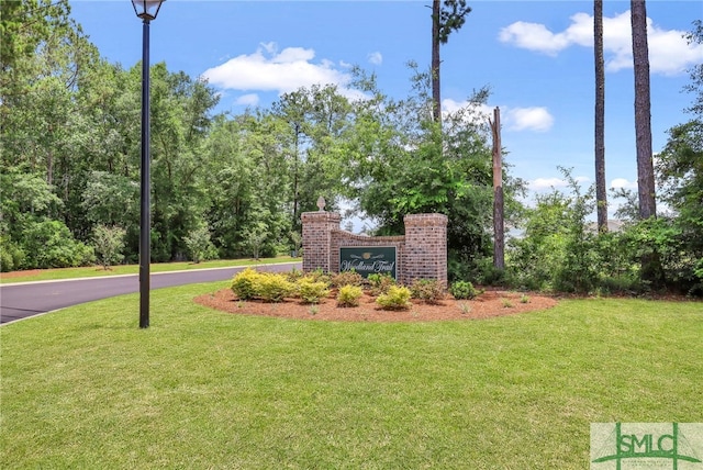 community / neighborhood sign with a yard