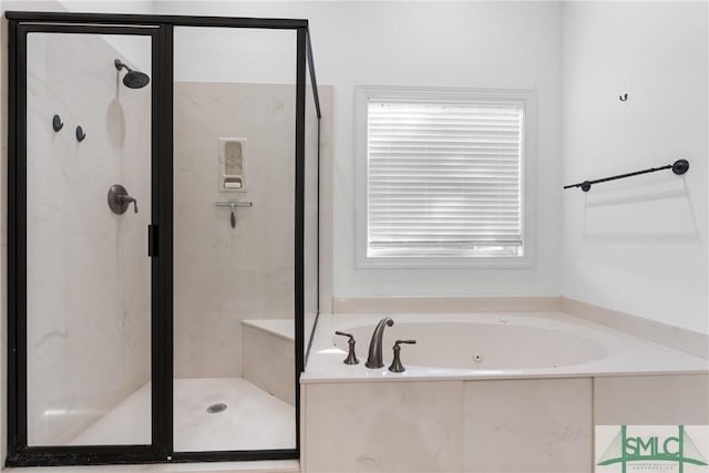 full bath featuring a wealth of natural light, a jetted tub, and a shower stall