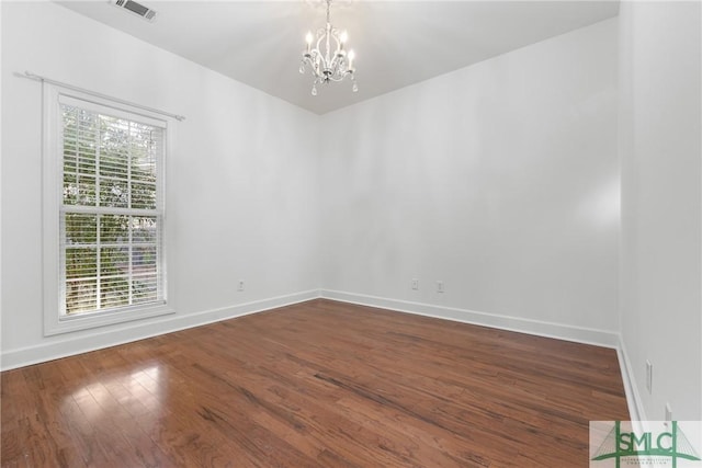 unfurnished room featuring a chandelier, visible vents, baseboards, and dark wood-style flooring