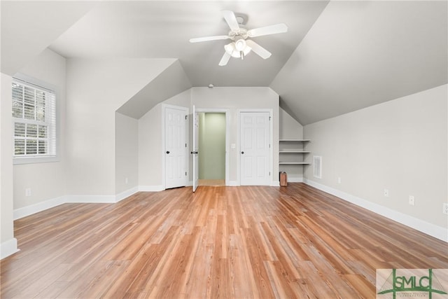 additional living space featuring a ceiling fan, lofted ceiling, baseboards, and light wood-type flooring