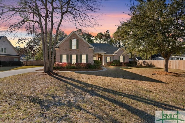 view of front of property with brick siding and fence