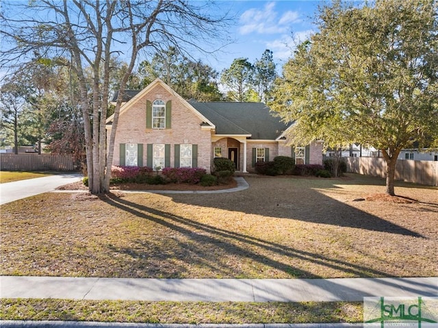 traditional-style house featuring brick siding and fence