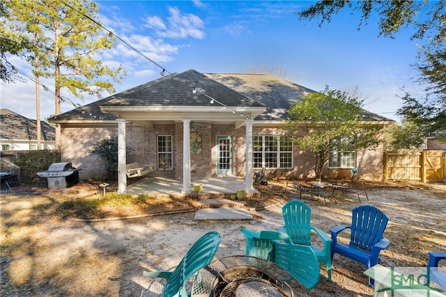 rear view of property with a patio area, fence, brick siding, and a shingled roof