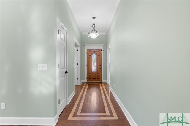 doorway to outside featuring wood finished floors, baseboards, and ornamental molding