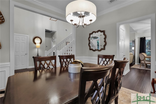 dining area with a notable chandelier, dark hardwood / wood-style floors, and crown molding