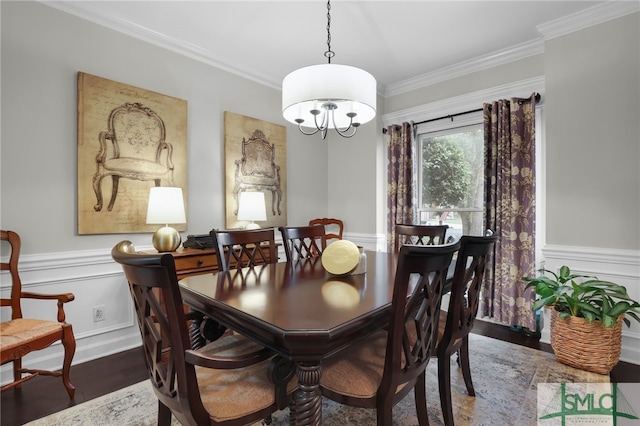 dining area featuring dark wood-type flooring, ornamental molding, and a notable chandelier