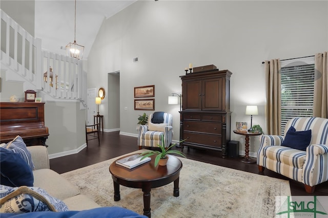 living room with dark hardwood / wood-style flooring, high vaulted ceiling, and a chandelier