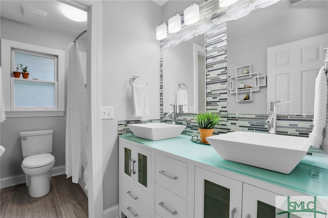 bathroom featuring tasteful backsplash, a shower with curtain, wood-type flooring, toilet, and vanity