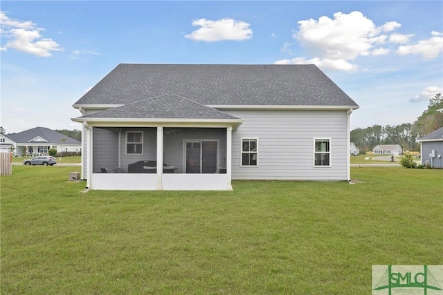 back of property with a yard and a sunroom