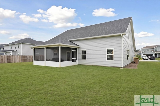 rear view of property featuring a sunroom and a yard