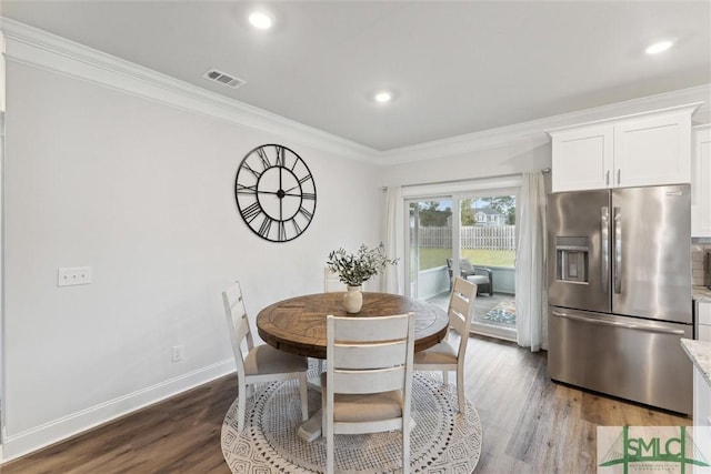 dining area with wood-type flooring and ornamental molding