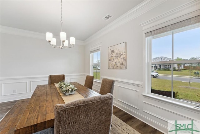 dining room featuring a wealth of natural light, dark hardwood / wood-style flooring, crown molding, and a notable chandelier