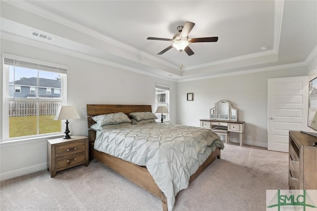 bedroom featuring light colored carpet, a raised ceiling, and ceiling fan