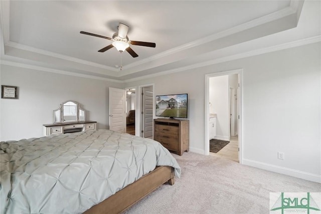 bedroom featuring light carpet, ensuite bathroom, ornamental molding, a raised ceiling, and ceiling fan