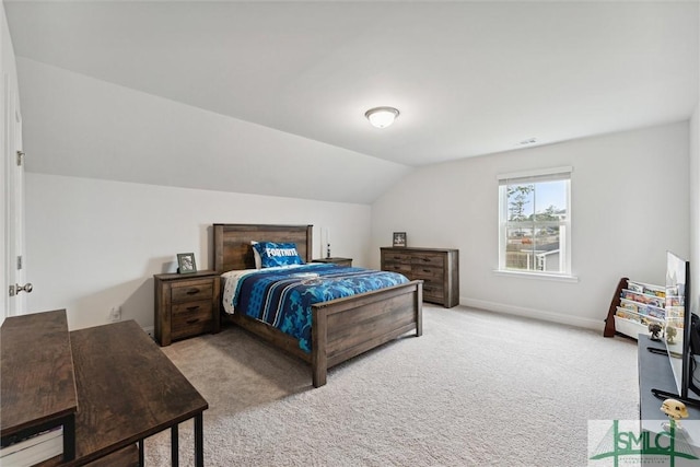 bedroom with light colored carpet and lofted ceiling