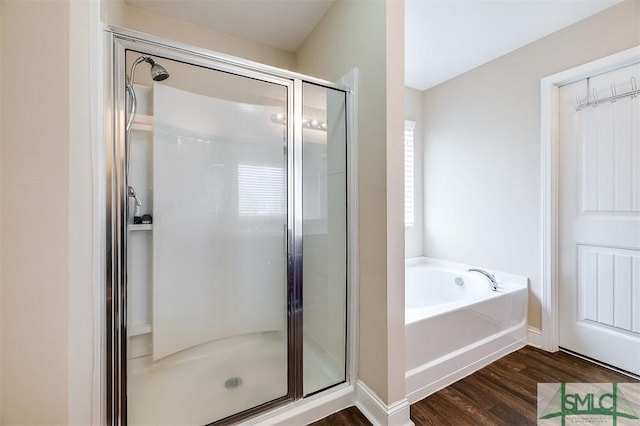 full bathroom featuring wood finished floors, a garden tub, and a stall shower