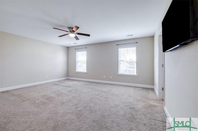 interior space featuring a ceiling fan, visible vents, light colored carpet, and baseboards