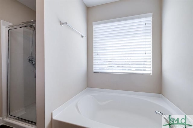 full bathroom featuring a shower stall and a garden tub