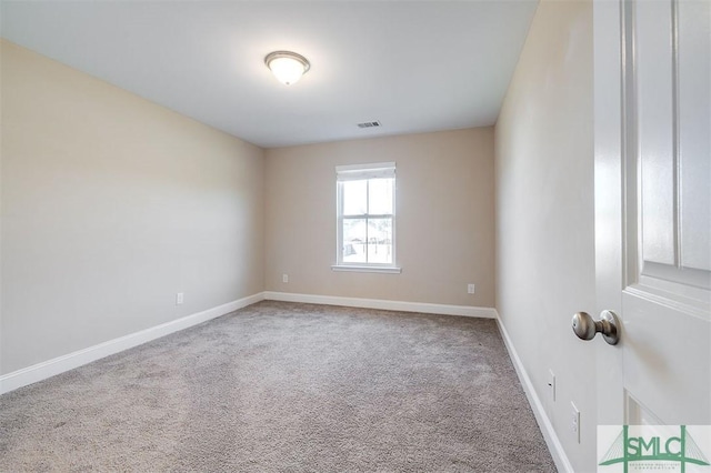 carpeted spare room with visible vents and baseboards