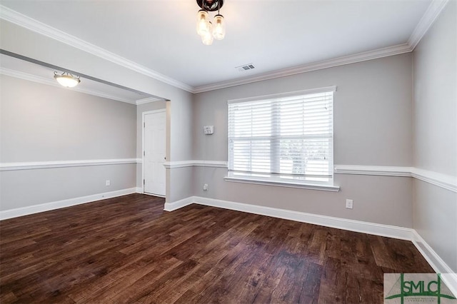 spare room featuring dark wood-style floors, visible vents, crown molding, and baseboards