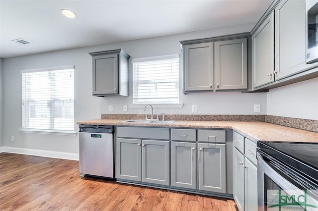 kitchen featuring visible vents, gray cabinets, appliances with stainless steel finishes, and a sink