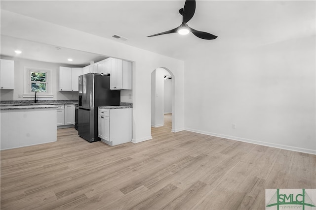 kitchen featuring white cabinets, light hardwood / wood-style floors, and stainless steel refrigerator