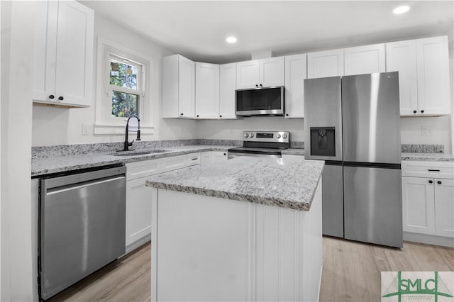 kitchen featuring white cabinets, a center island, sink, and appliances with stainless steel finishes