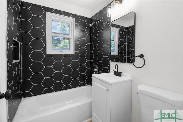 full bathroom featuring tiled shower / bath combo, toilet, and vanity