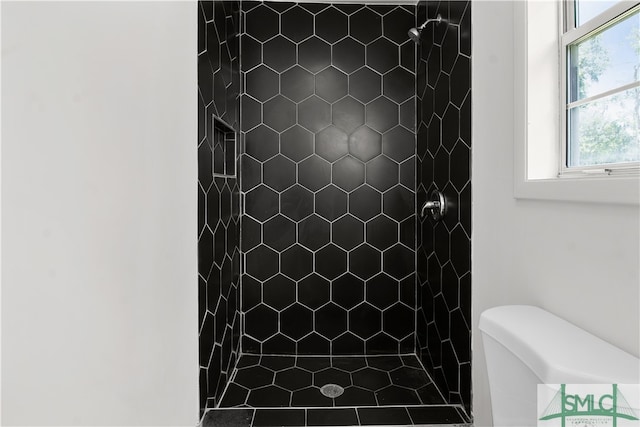 bathroom featuring tiled shower, plenty of natural light, and toilet