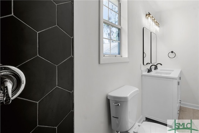 bathroom featuring vanity, hardwood / wood-style flooring, and toilet