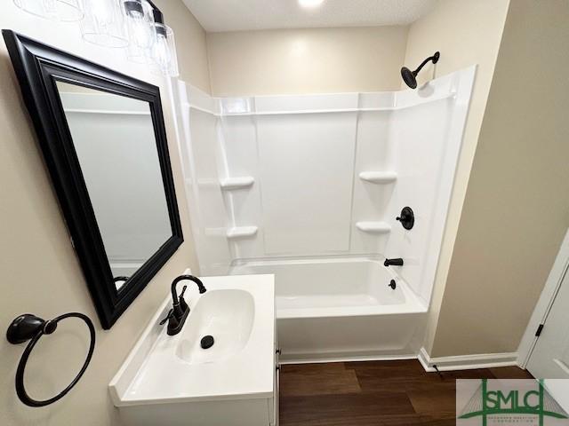 bathroom featuring bathtub / shower combination, vanity, and hardwood / wood-style flooring