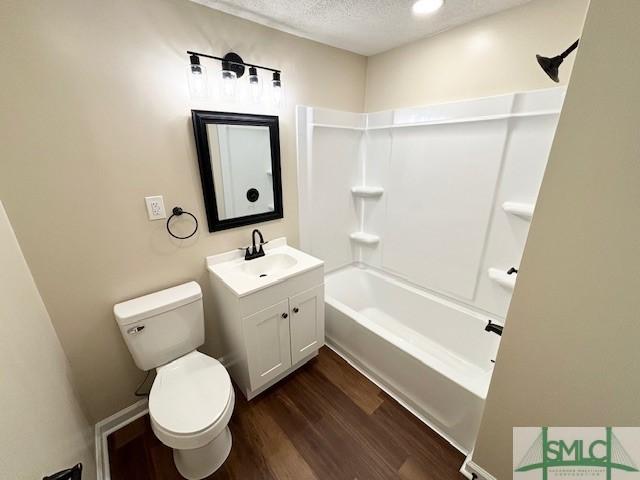 full bathroom featuring shower / bath combination, vanity, a textured ceiling, wood-type flooring, and toilet