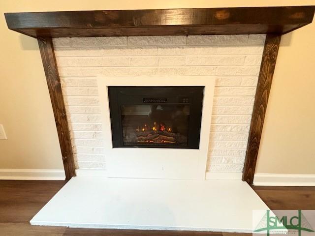 interior details featuring hardwood / wood-style flooring and a brick fireplace