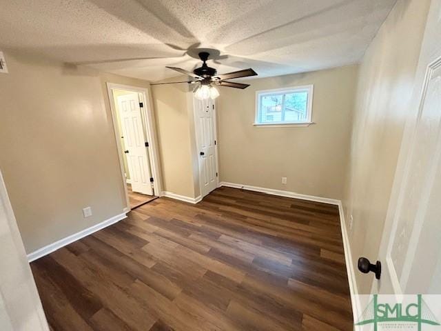 unfurnished room with ceiling fan, dark hardwood / wood-style flooring, and a textured ceiling